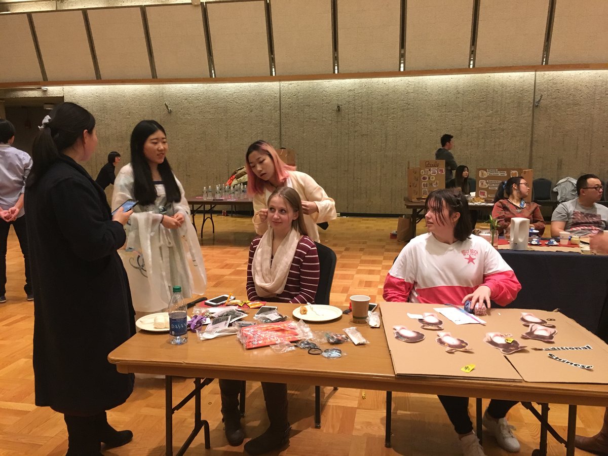Festival attendees in traditional dress at a cultural exhibition table